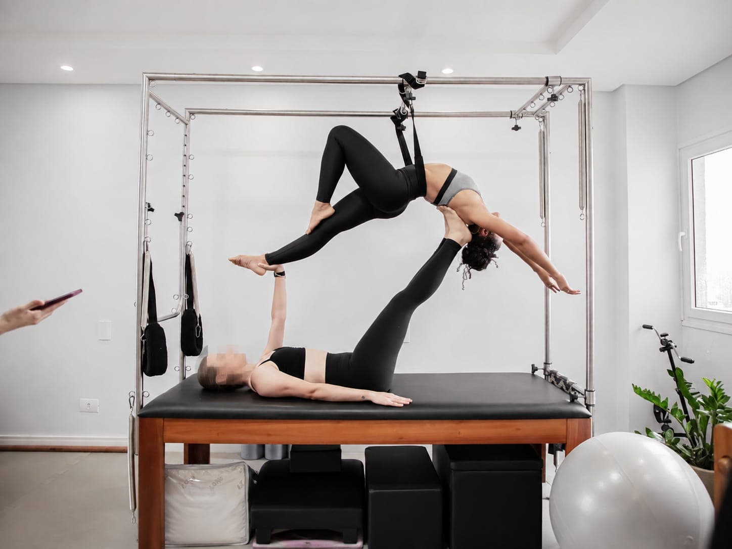 Exercício de Pilates em dupla no Cadillac na Clínica Black Belt Fisioterapia